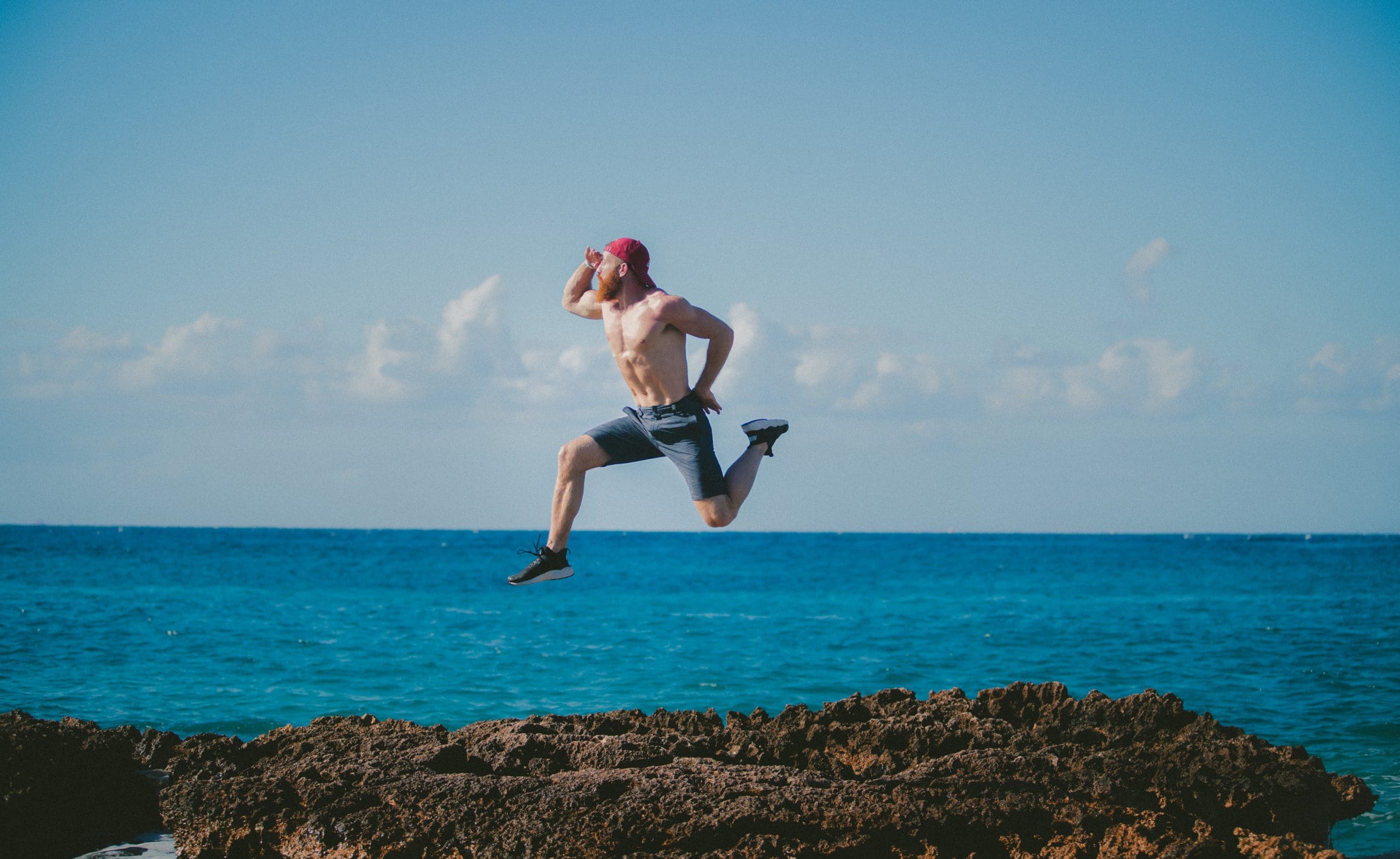 Man jumping on rocks by the ocean.jpg