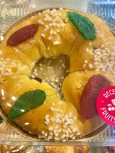 Une couronne briochée décorée de fruits confits et de sucre perlé, typique de la tradition de la galette des rois.